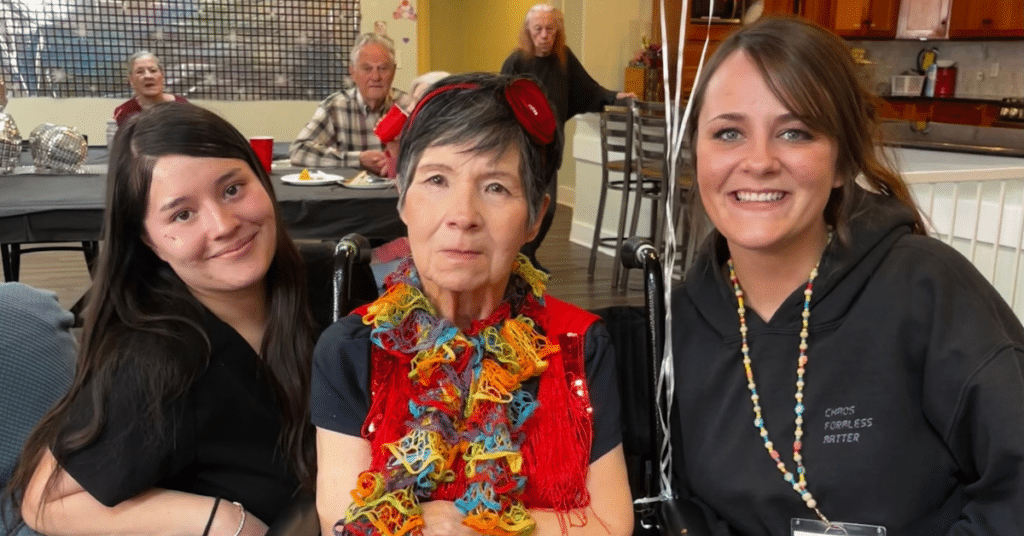 How Much Does Memory Care Cost In Colorado? A 2026 Budget Guide 1 Resident-At-Applewood-Our-Home-Posing-With-Staff-At-An-Activity